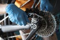 Gloved handyman fixing bicycle chain with tools closeup