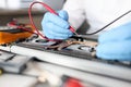 Gloved handyman repairs motherboard. Maintenance and repair of computer equipment