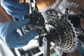 Gloved handyman repairs rear bicycle cassette closeup