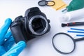 A gloved photographer holds his DSLR camera without a lens before cleaning the sensor