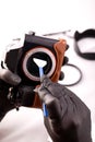 A gloved photographer takes care of photographic equipment with special tools.