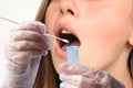 Gloved technician takes a sample of a woman`s saliva from her mouth for DNA analysis, concept of police investigation and medical