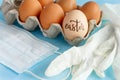 Gloves, facemask and eggs with inscription EASTER over blue background Royalty Free Stock Photo