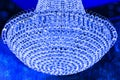 Glow Crystal Lighting or chrome chandelier isolated on blue background. Branched ornamental light fixture. 