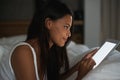 Glow in the dark. a beautiful young woman relaxing in bed with her tablet. Royalty Free Stock Photo