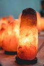 Glow salt lamp, dark vintage wooden background, vertical