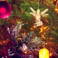 A glowing angel from glass hanging on a christmas tree