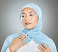 A glowing beautiful muslim woman isolated against grey copyspace background. Young woman wearing a hijab or headscarf Royalty Free Stock Photo