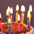 Glowing Birthday Candles and Sprinkles On a Cake