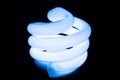 Glowing blue CFL energy saving spiral bulb. Close up. Royalty Free Stock Photo