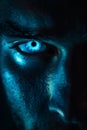 Glowing blue eye of a mysterious man. Serious expression Royalty Free Stock Photo