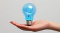 Glowing blue light bulb held in a hand Royalty Free Stock Photo