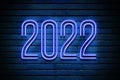 2022 glowing blue neon text on brick wall