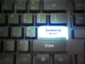 A glowing bright `contact us` button, key, message on the keyboard. Customer service concept. Internet or online contact for