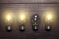 Glowing bulbs weak link concept on wooden Royalty Free Stock Photo