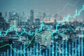 Glowing business chart hologram and index on blurry city background. Finance, trade and invest concept. Royalty Free Stock Photo