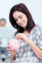 Glowing businesswoman saving money in a piggy-bank Royalty Free Stock Photo