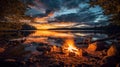 Glowing campfire by the lake. Sunset with open flames, fire, and logs. Camping on the beach at night. Serene lake landscape. Royalty Free Stock Photo