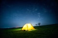 Glowing camping tent in the night mountains under a starry sky Royalty Free Stock Photo