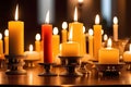 Glowing candles in golden candle holders on a wooden table against a dark background