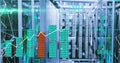 Glowing central server rack row showing bar chart overlays and trend lines inside datacenter aisle Royalty Free Stock Photo