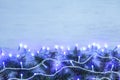 Glowing Christmas lights and fir branches on wooden background Royalty Free Stock Photo