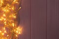 Glowing Christmas lights on pink wooden background. Space for text Royalty Free Stock Photo