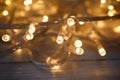 Glowing Christmas lights on wooden background, closeup Royalty Free Stock Photo