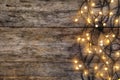 Glowing Christmas lights on wooden background Royalty Free Stock Photo