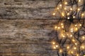 Glowing Christmas lights on wooden background