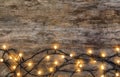 Glowing Christmas lights on wooden background