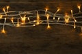 Glowing Christmas lights on wooden background, top view Royalty Free Stock Photo