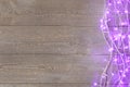 Glowing Christmas lights on wooden background, top view Royalty Free Stock Photo