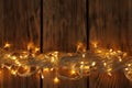 Glowing Christmas lights on wooden background, top view Royalty Free Stock Photo