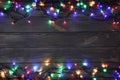 Glowing Christmas lights on wooden background, top view. Space for text Royalty Free Stock Photo