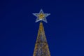 glowing Christmas tree against the background of the night blue sky Royalty Free Stock Photo