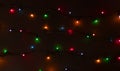 Glowing colorful Christmas lights on black background