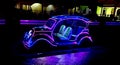 Photo of glowing LED lights in a row and in the shape of a classic car