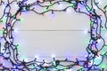 Glowing colourful christmas lights on wooden background