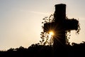 Glowing cross silhouette with sunbeams sunset sunlight and clear evening sky shows christianity spirituality of church and forgive