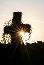 Glowing cross silhouette with sunbeams sunset sunlight and clear evening sky shows christianity spirituality of church and forgive