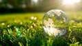 Crystal globe on grass with sunlight. Symbol of global ecology and nature. Perfect for environmental themes. Serene and Royalty Free Stock Photo