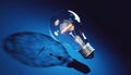 Glowing 3 D Lightbulb with Filament on Dark Blue Gradient Background Royalty Free Stock Photo