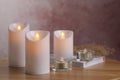 Glowing decorative LED candles on wooden table Royalty Free Stock Photo