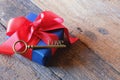 Glowing deep blue with red ribbon gift box and Love key shape on vintage wooden table. A present with love concept. Backdrop for Royalty Free Stock Photo