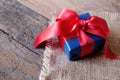 Glowing deep blue with red ribbon gift box on vintage wooden table. A present with love concept. Backdrop for Valentine& x27;s day Royalty Free Stock Photo