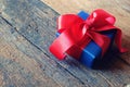 Glowing deep blue with red ribbon gift box on vintage wooden table. A present with love concept. Backdrop for Valentine& x27;s day Royalty Free Stock Photo