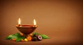 Glowing Diya with sacred elements on brown background Royalty Free Stock Photo
