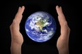 Glowing earth globe in hands on black, environment concept - elements of this image furnished by NASA Royalty Free Stock Photo