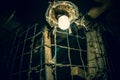 Glowing electric lamp covered in cobwebs in an old creepy barn